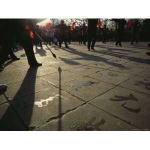 During a Fan Dance, Old Men Paint Chinese Characters on the Pavement 