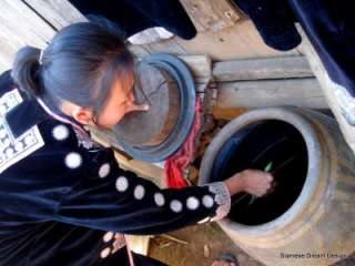   ladies preparing the indigo dye and drawing the batik patterns in wax