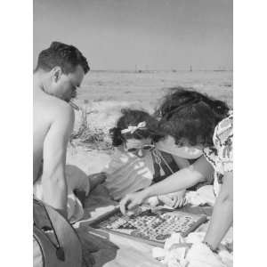  Man and Two Women Playing Chinese Checkers at Beach 